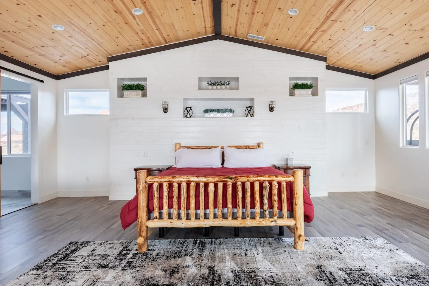 Bedroom with a log-frame bed under a vaulted wood ceiling